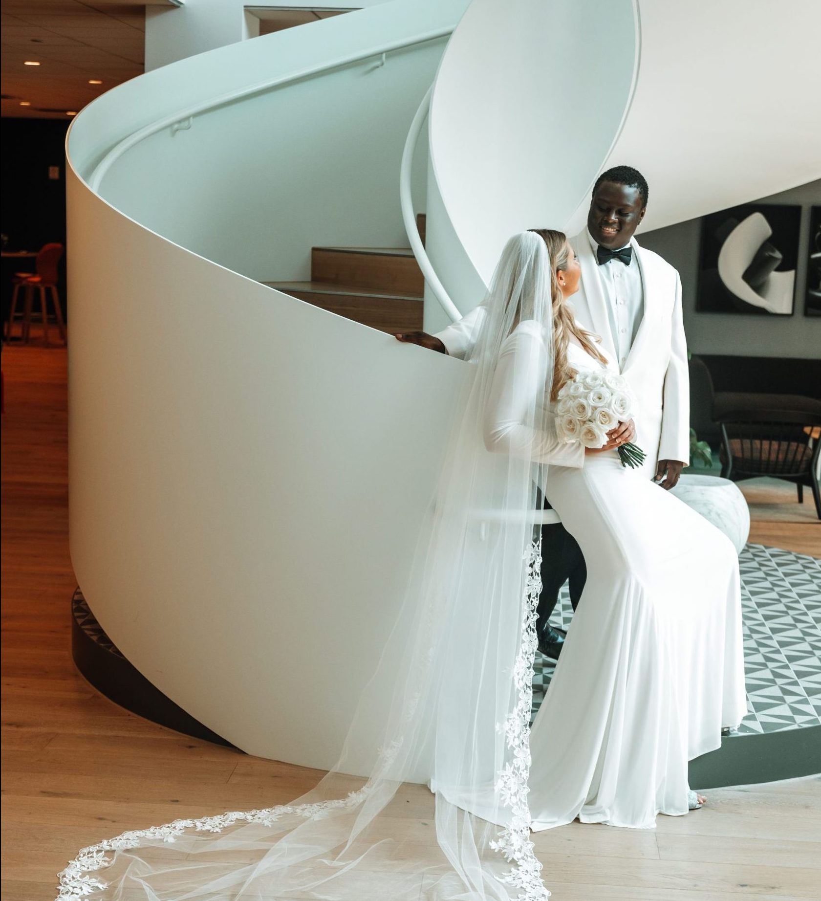 couple leaning on lobby staircase annie lane bridal garments